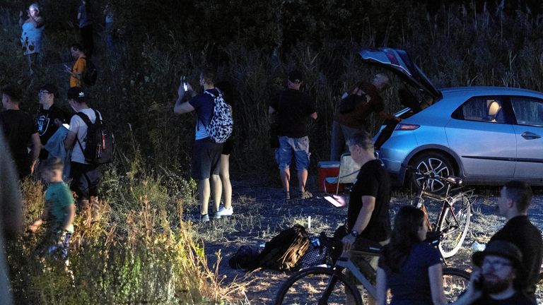 Lidé stojí poblíž scény, kde se během zkoušky na nátěru v Polsku Radom v Polsku na havaroval polské letectvo F-16. Pic: Agencja wyborcza.pl/Marcin Kucewicz/Reuters
