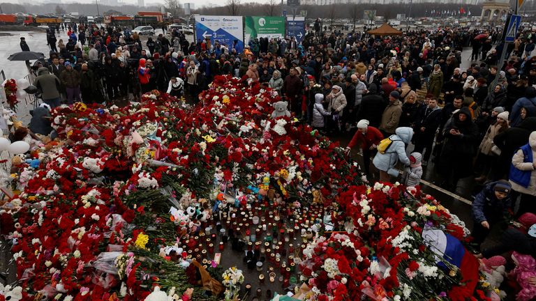 Lidé se shromažďují u provizorního památníku obětem střeleckého útoku zřízeného mimo konání koncertu radnice Crocus v Moskvě re