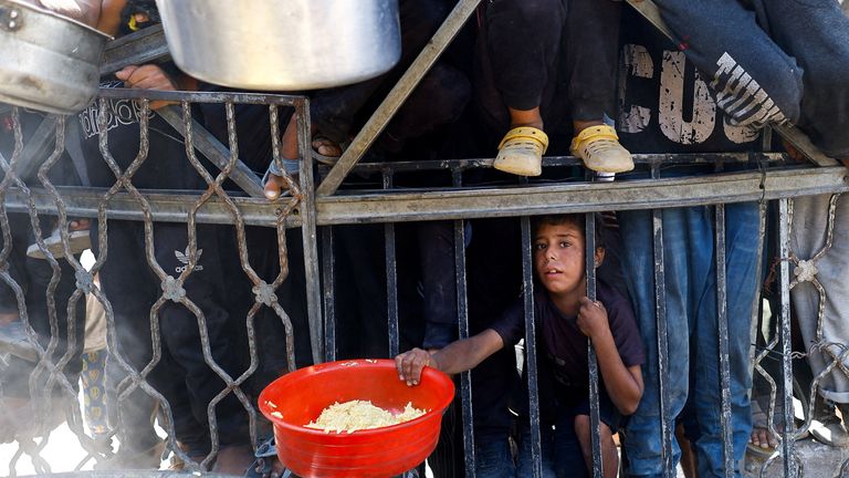 Palestinské dítě čeká na přijetí jídla z charitativní kuchyně ve městě Gazy. Pic: Reuters/Mahmúd Issa