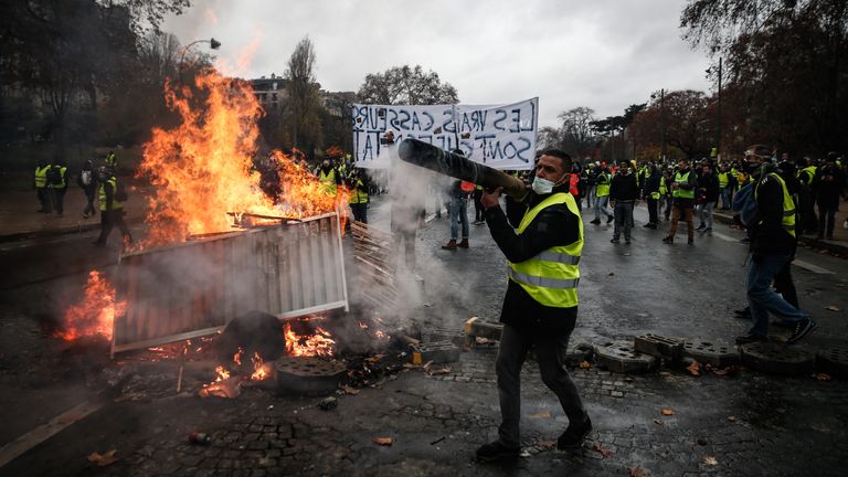 Gilets Jaunes staví barikádu v Paříži během protestů proti vysokým životním nákladům v roce 2018.