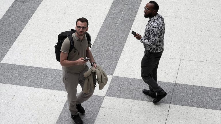 Lidé kontrolují své telefony na London Liverpool Street. Pic: Pa