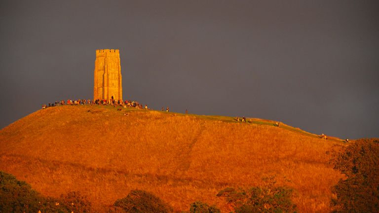 Brzy večerní sluneční světlo zasáhne Glastonbury Tor v Somersetu, když se lidé shromažďují v naději, že uvidí krevní měsíc. Pic: Pa