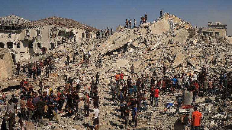 Palestinci kontrolují místo zhroucené budovy ve městě Gazy po izraelské stávce v pondělí. Pic: Reuters