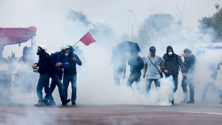 Protestující stojí uprostřed slzného plynu postříkaného policií. Pic: Reuters