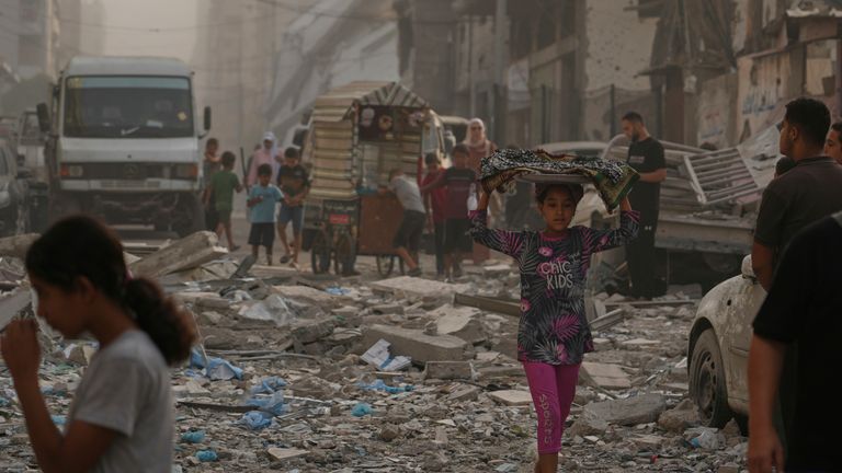 Palestinská dívka prochází silně poškozenou budovou ve městě Gazy, den poté, co ji zasáhla izraelská stávka. Pic: AP/JEHAD ALSHRAFI