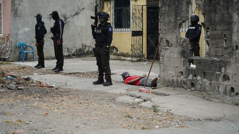 Podezřelý leží na zemi, když policejní strážce 