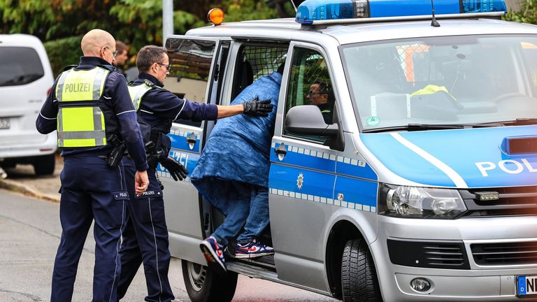 Byl vidět teenager, který byl vložen do policejní dodávky. Pic: Ap