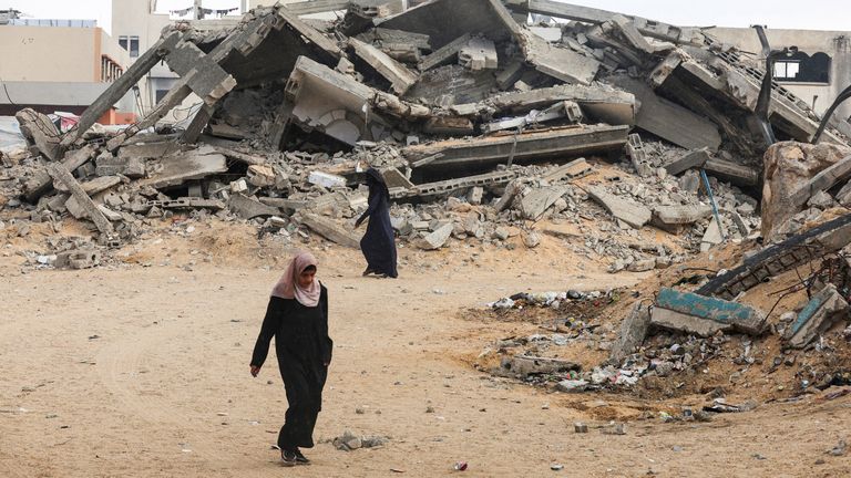 Palestinské ženy chodí poblíž trosky v jižní Gaze. Pic: Reuters